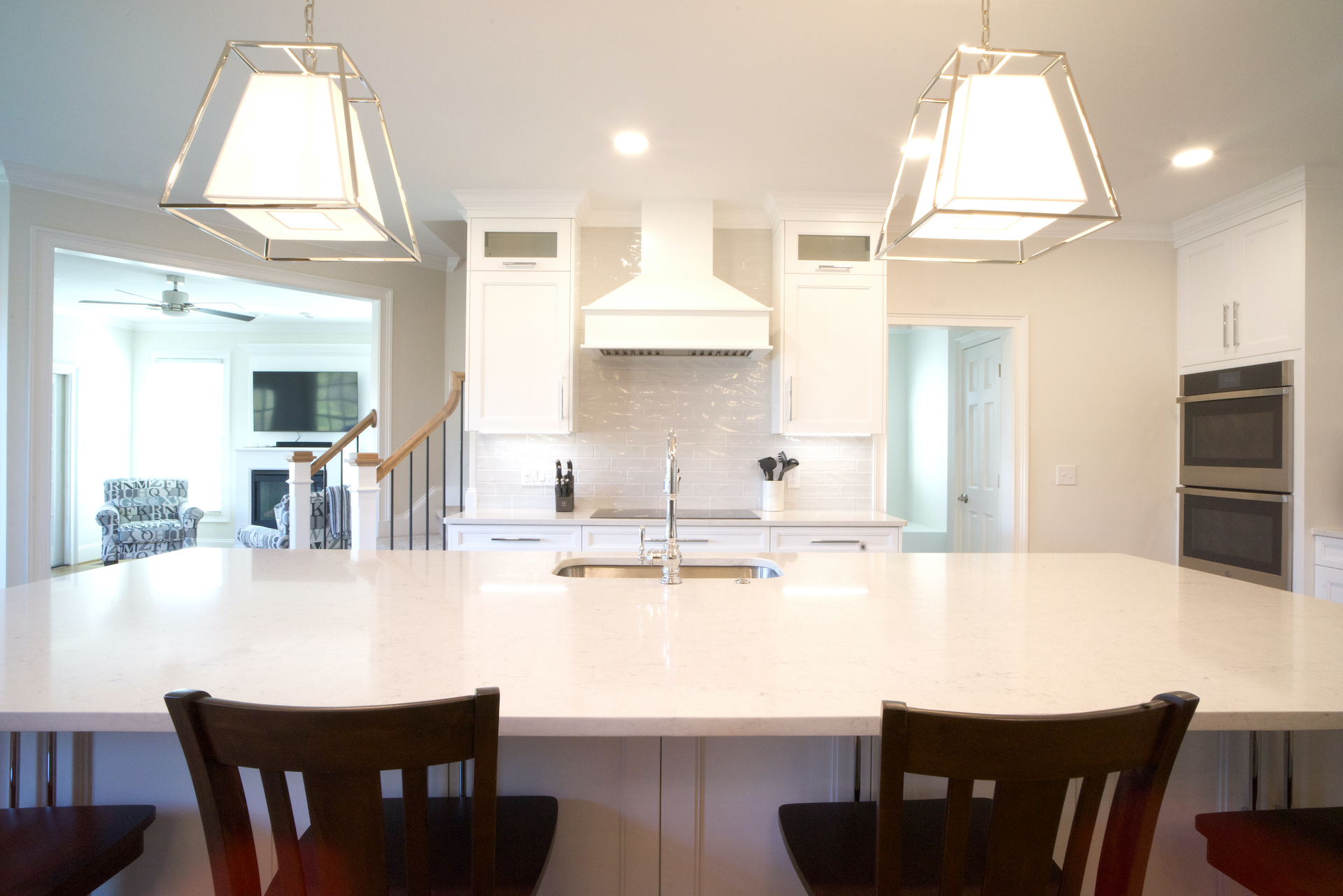 Large white kitchen with classic large subway tiles and an extra large island with sink
